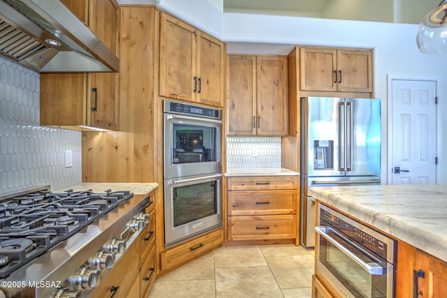 218 W Milbrae Springs Dr, Oro Valley, AZ 85755 - kitchen featuring range hood, stainless steel appliances, light tile patterned flooring, tasteful backsplash, and brown cabinets