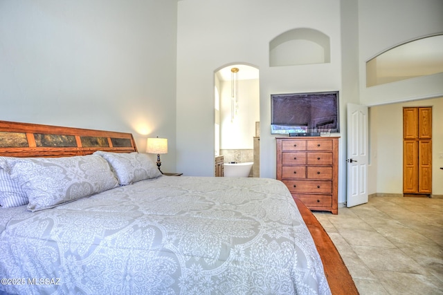 218 W Milbrae Springs Dr, Oro Valley, AZ 85755 - bedroom with a towering ceiling, ensuite bathroom, and baseboards