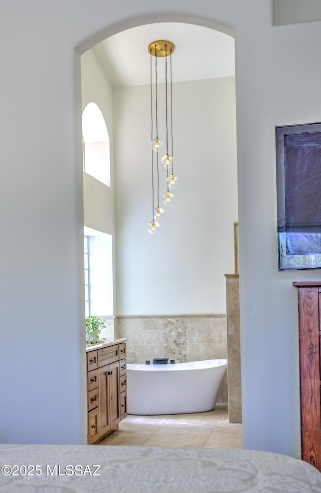 218 W Milbrae Springs Dr, Oro Valley, AZ 85755 - bathroom with a freestanding bath, tile walls, tile patterned floors, vanity, and a wainscoted wall