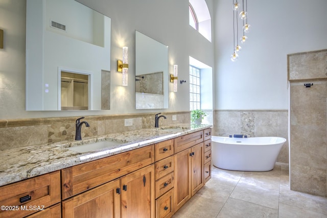 218 W Milbrae Springs Dr, Oro Valley, AZ 85755 - full bath with tile walls, a freestanding bath, a towering ceiling, healthy amount of natural light, and double vanity