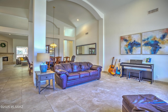 218 W Milbrae Springs Dr, Oro Valley, AZ 85755 - living room featuring high vaulted ceiling, a fireplace with raised hearth, and arched walkways