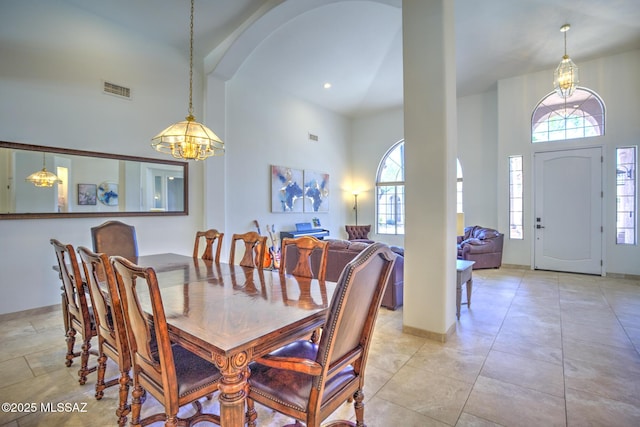 218 W Milbrae Springs Dr, Oro Valley, AZ 85755 - dining room featuring a towering ceiling, a chandelier, arched walkways, and recessed lighting