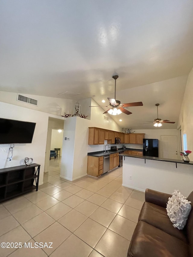 115 W Birdman Dr, Tucson, AZ 85705 - living area featuring light tile patterned floors, vaulted ceiling, ceiling fan, and baseboards