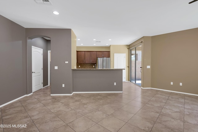 2247 W Night Air Ln, Tucson, AZ 85741 - unfurnished living room with arched walkways, light tile patterned floors, recessed lighting, and baseboards