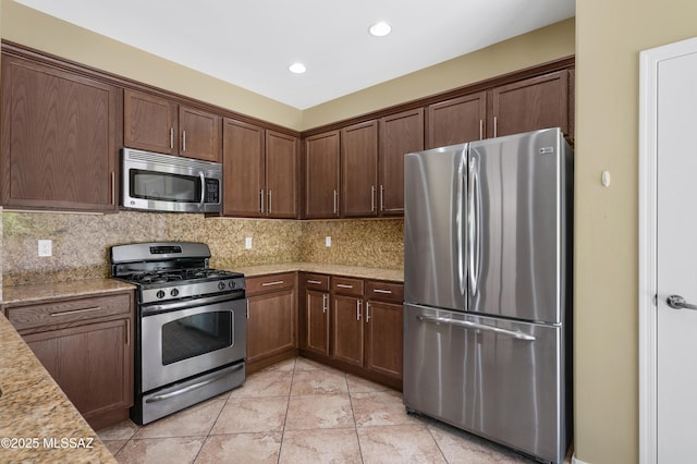 2247 W Night Air Ln, Tucson, AZ 85741 - kitchen with appliances with stainless steel finishes, decorative backsplash, recessed lighting, light tile patterned floors, and light stone countertops