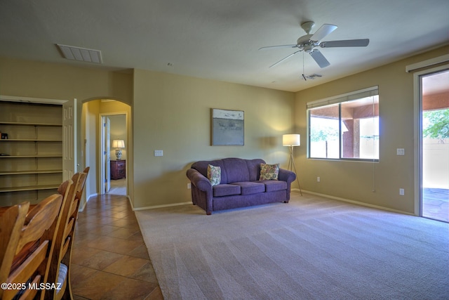 11113 N Rams Horn Trl N, Oro Valley, AZ 85737 - living room with arched walkways, a ceiling fan, baseboards, and carpet