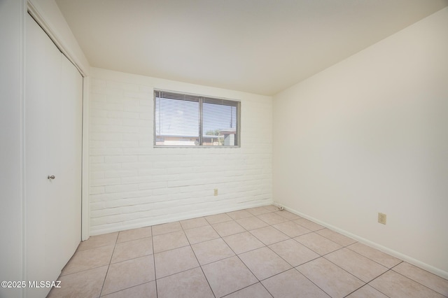 3025 E Blacklidge Dr, Tucson, AZ 85716 - empty room featuring brick wall and light tile patterned floors