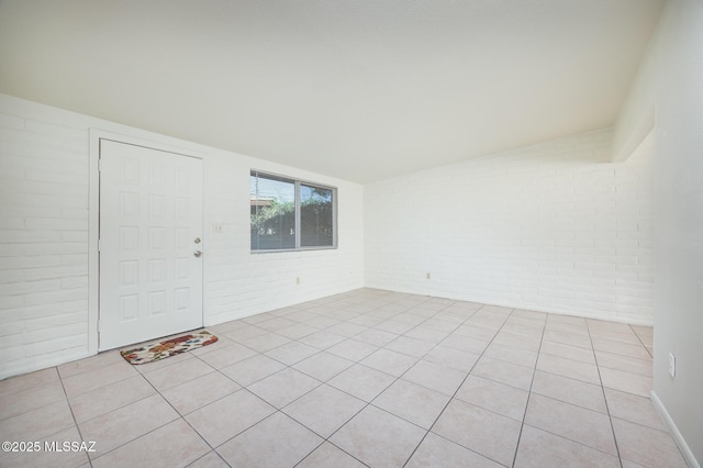 3025 E Blacklidge Dr, Tucson, AZ 85716 - empty room featuring brick wall and light tile patterned floors