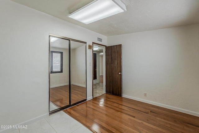 6158 E Calle Aurora, Tucson, AZ 85711 - unfurnished bedroom featuring light wood finished floors, baseboards, and a closet