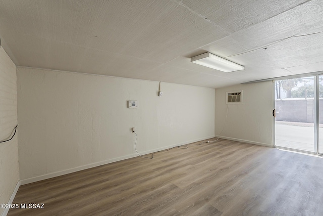 6158 E Calle Aurora, Tucson, AZ 85711 - unfurnished room with wood finished floors, baseboards, and a wall mounted air conditioner