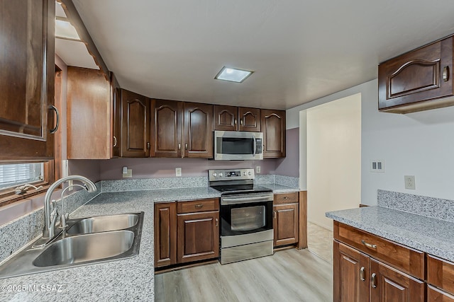 6158 E Calle Aurora, Tucson, AZ 85711 - kitchen with stainless steel appliances, a sink, light wood-style flooring, light countertops, and dark brown cabinets