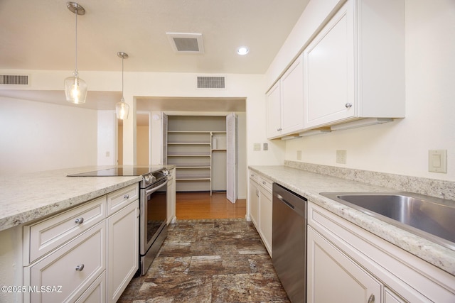 9846 E 2nd St, Tucson, AZ 85748 - kitchen featuring appliances with stainless steel finishes, white cabinets, and hanging light fixtures