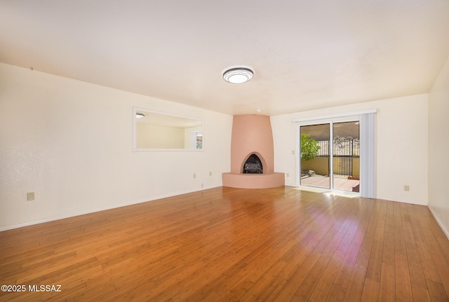 9846 E 2nd St, Tucson, AZ 85748 - unfurnished living room featuring a fireplace, hardwood / wood-style flooring, and baseboards