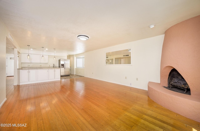 9846 E 2nd St, Tucson, AZ 85748 - unfurnished living room featuring light wood finished floors and baseboards