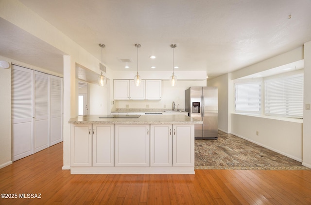 9846 E 2nd St, Tucson, AZ 85748 - kitchen featuring stainless steel refrigerator with ice dispenser, light wood finished floors, a sink, white cabinetry, and black electric cooktop