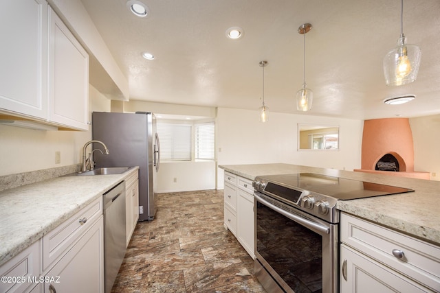 9846 E 2nd St, Tucson, AZ 85748 - kitchen with stainless steel appliances, a sink, white cabinetry, pendant lighting, and stone finish flooring