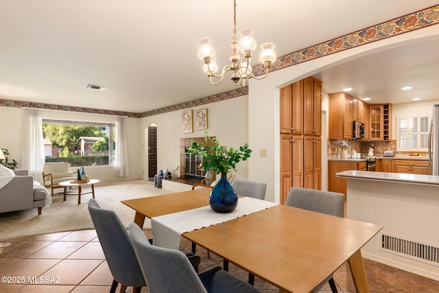 2826 E Kleindale Rd, Tucson, AZ 85716 - dining area featuring arched walkways, light tile patterned floors, a chandelier, recessed lighting, and light colored carpet