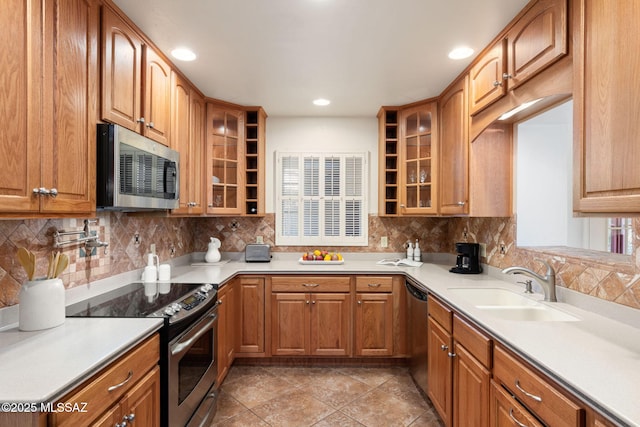 2826 E Kleindale Rd, Tucson, AZ 85716 - kitchen featuring appliances with stainless steel finishes, a sink, glass insert cabinets, tasteful backsplash, and light countertops