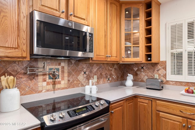 2826 E Kleindale Rd, Tucson, AZ 85716 - kitchen featuring stainless steel appliances, glass insert cabinets, light countertops, and backsplash
