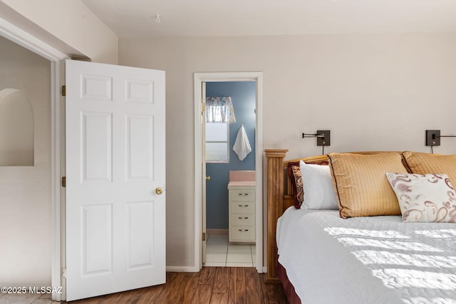 2826 E Kleindale Rd, Tucson, AZ 85716 - bedroom with wood finished floors, ensuite bathroom, and baseboards