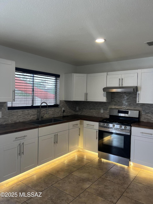 1558 E Los Cabos Pl, Tucson, AZ 85706 - kitchen featuring stainless steel gas stove, a sink, under cabinet range hood, dark countertops, and a textured ceiling