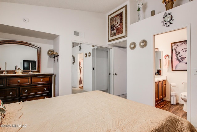 10095 E Autumnwind Pl, Tucson, AZ 85730 - bedroom featuring wood finished floors, vaulted ceiling, ensuite bathroom, and a closet
