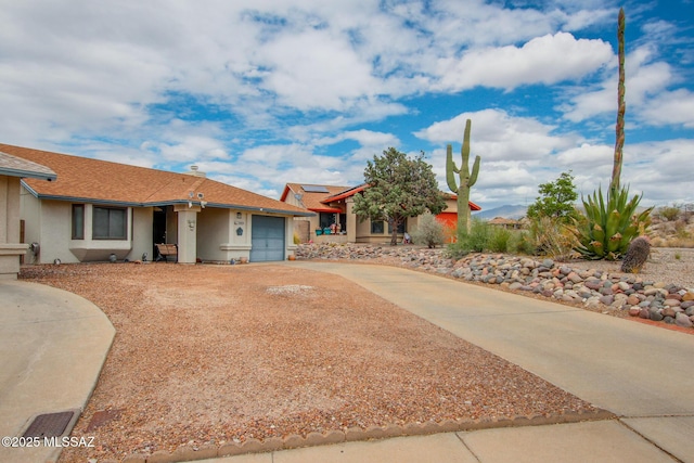 10095 E Autumnwind Pl, Tucson, AZ 85730 - view of front facade with driveway, a garage, and stucco siding