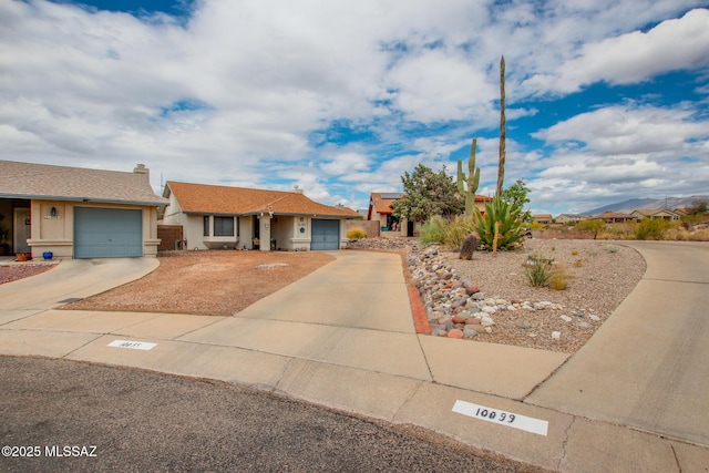 10095 E Autumnwind Pl, Tucson, AZ 85730 - single story home with concrete driveway, a garage, and stucco siding