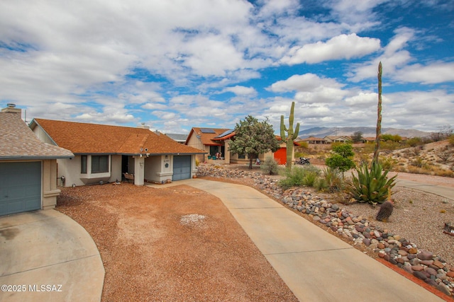 10095 E Autumnwind Pl, Tucson, AZ 85730 - single story home with concrete driveway, an attached garage, stucco siding, and a mountain view