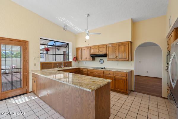 1861 N Camino Claveles, Tucson, AZ 85745 - kitchen featuring a peninsula, light tile patterned flooring, a towering ceiling, a ceiling fan, and light stone counters