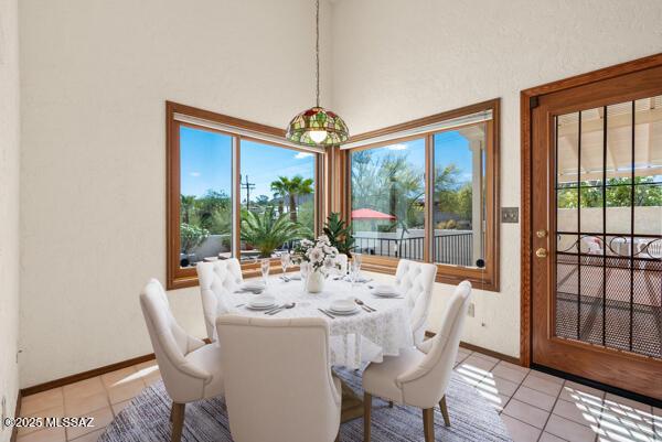 1861 N Camino Claveles, Tucson, AZ 85745 - dining space with light tile patterned floors, baseboards, and a towering ceiling