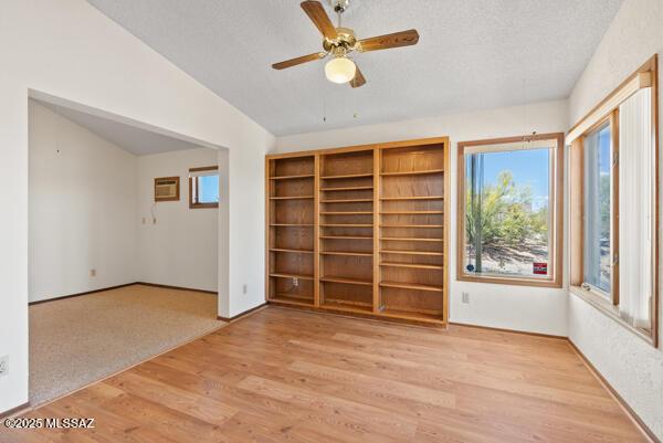 1861 N Camino Claveles, Tucson, AZ 85745 - spare room featuring vaulted ceiling, wood finished floors, a textured ceiling, and a ceiling fan