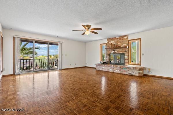 1861 N Camino Claveles, Tucson, AZ 85745 - unfurnished living room featuring baseboards, a ceiling fan, a textured ceiling, and a fireplace