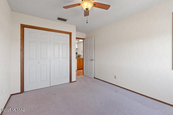 1861 N Camino Claveles, Tucson, AZ 85745 - unfurnished bedroom featuring light colored carpet, a closet, baseboards, and ceiling fan