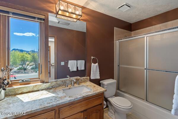 1861 N Camino Claveles, Tucson, AZ 85745 - full bath featuring toilet, vanity, and combined bath / shower with glass door