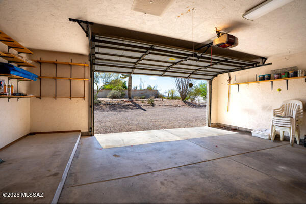 1861 N Camino Claveles, Tucson, AZ 85745 - garage featuring a garage door opener and baseboards