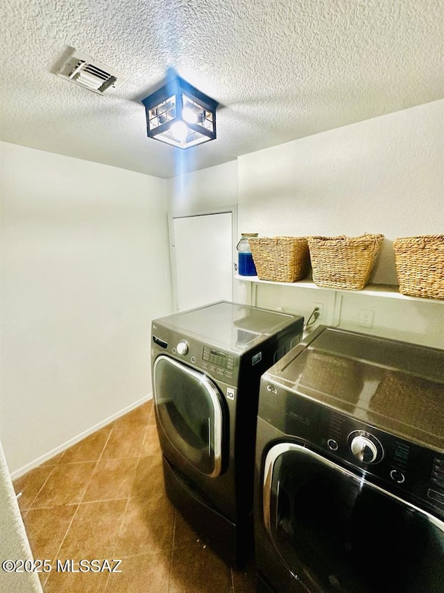 3756 W Exton Ln, Tucson, AZ 85746 - laundry room featuring washer and clothes dryer, a textured ceiling, and tile patterned flooring