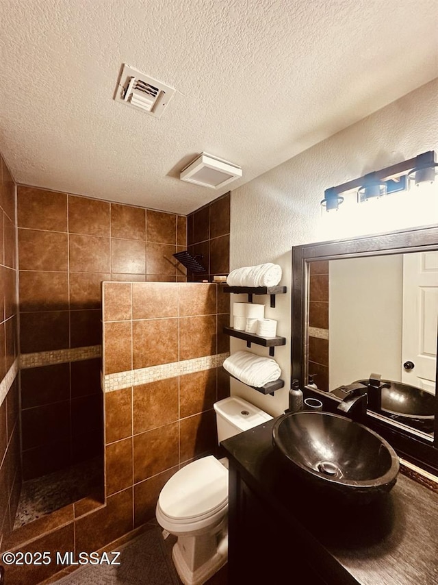 3756 W Exton Ln, Tucson, AZ 85746 - bathroom featuring walk in shower, a textured ceiling, vanity, and a textured wall