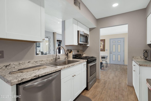210 S Abrego Dr, Green Valley, AZ 85614 - kitchen featuring stainless steel appliances, a sink, white cabinetry, light wood-type flooring, and recessed lighting