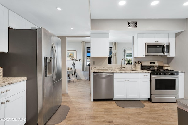 210 S Abrego Dr, Green Valley, AZ 85614 - kitchen with stainless steel appliances, a sink, white cabinetry, light wood-type flooring, and recessed lighting