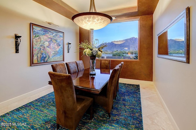 tiled dining space featuring baseboards, a mountain view, and healthy amount of natural light