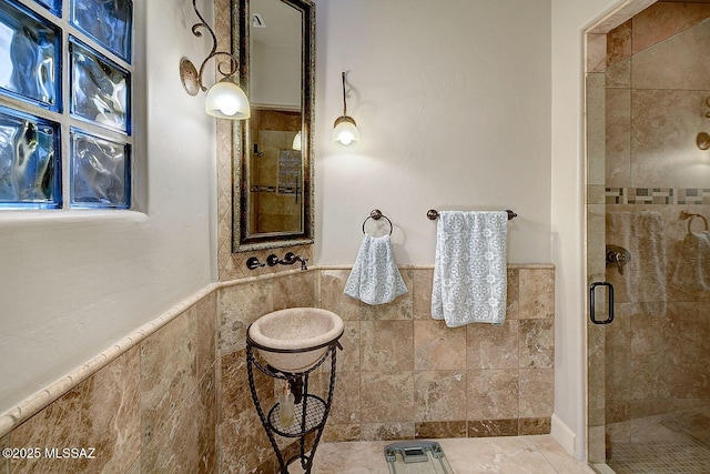 full bath with tile walls, a shower stall, and wainscoting