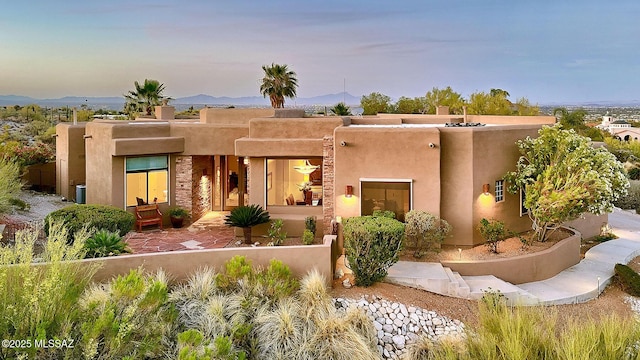 pueblo revival-style home featuring stucco siding and a mountain view