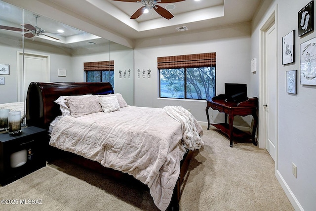 bedroom with a raised ceiling, carpet, baseboards, recessed lighting, and ceiling fan