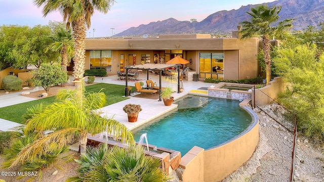 outdoor pool featuring a mountain view, an in-ground hot tub, and a patio area