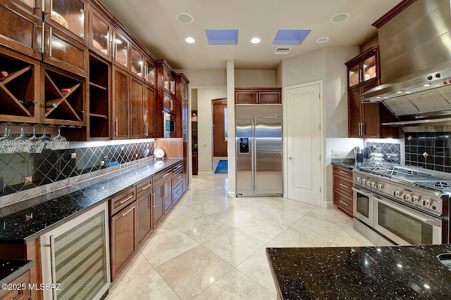 kitchen featuring built in appliances, beverage cooler, open shelves, wall chimney range hood, and decorative backsplash