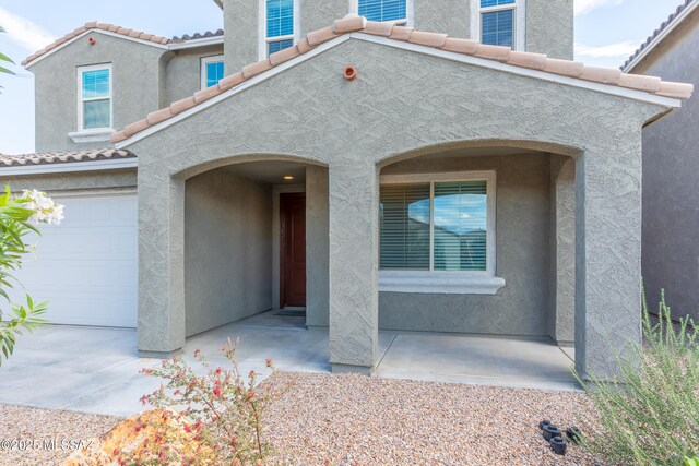 9734 E Miller Peak Trl, Tucson, AZ 85747 - view of front of home featuring a tile roof, stucco siding, and a garage