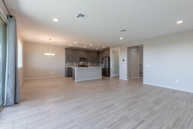 9734 E Miller Peak Trl, Tucson, AZ 85747 - kitchen featuring fridge with ice dispenser, open floor plan, stainless steel microwave, a chandelier, and recessed lighting