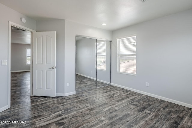 3526 E Farrier Dr, Tucson, AZ 85739 - unfurnished bedroom with dark wood-style flooring, baseboards, and a closet