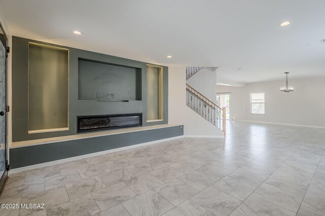 3526 E Farrier Dr, Tucson, AZ 85739 - unfurnished living room with stairway, a glass covered fireplace, a chandelier, baseboards, and recessed lighting